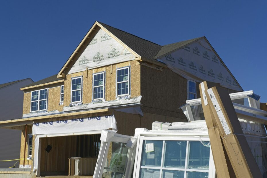 New home under construction with sheathing and windows ready to install