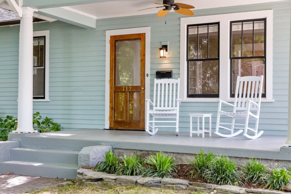 Front porch of a newly finished home with white rocking chairs